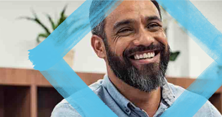 1. Two men smiling; one holds a blue square, adding a playful element to the cheerful scene.