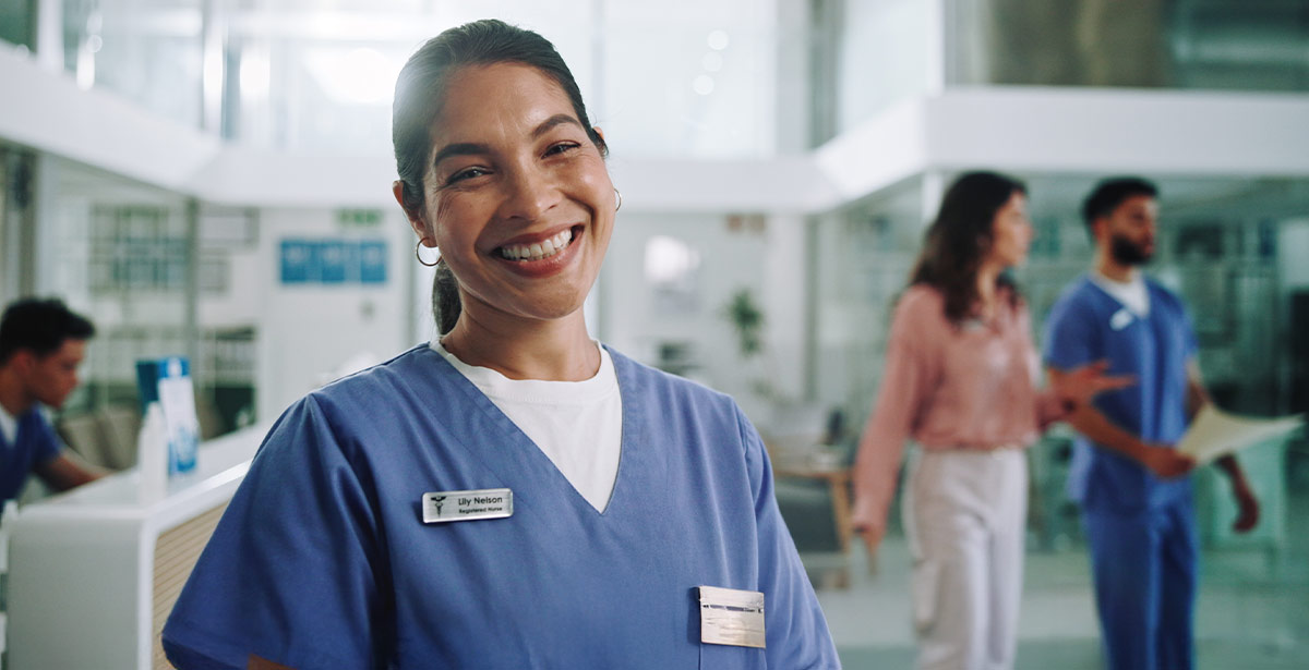 1. A smiling nurse stands in a hospital hallway, wearing scrubs and a stethoscope, conveying a sense of care and professionalism.