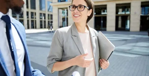 Financial analyst discusing complex fiscal reports to develop essential skills for business growth strategies while walking.