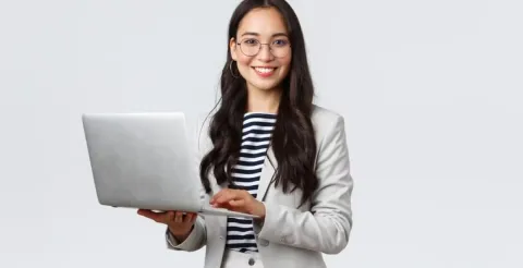 Financial planner happily reviewing investment data on a modern computer for professional client analysis.