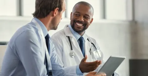 Healthcare professional engaged in a consultation with a patient in a modern clinical setting.