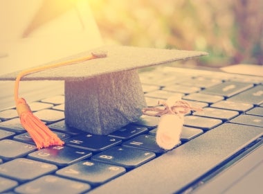 An MBA graduate cap on a laptop.