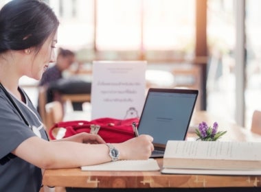 A VU Online Master of Nursing student sits at a desk with her laptop.