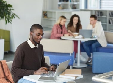 A financial planning student studies for the FASEA exam on their laptop.