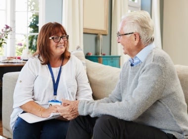 A mental health worker helping an elderly adult.