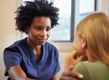 A mental health nurse comforting and helping a patient.
